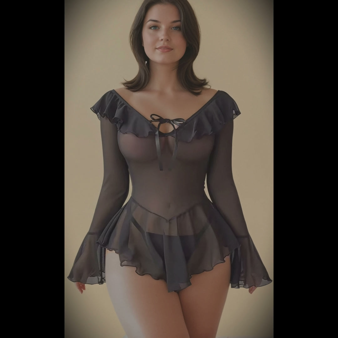 Woman wearing a sheer black long-sleeve top with ruffled details on a plain background